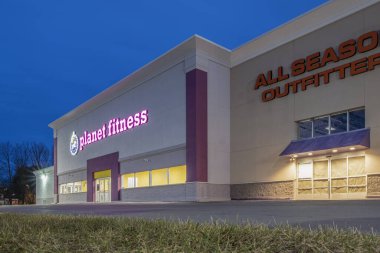 New Hartford, New York - Mar 19, 2020: Night View of Planet Fitness Gym and Workout Center, Planet Fitness Identifies Itself as a Judgment Free Zone. clipart