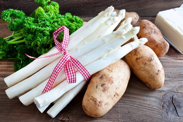 Ahşap arka planda kuşkonmaz ve patates.