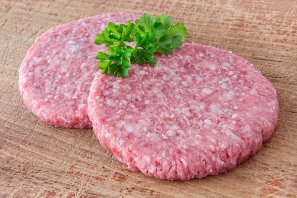 Carne de hambúrguer no fundo de madeira — Fotografia de Stock