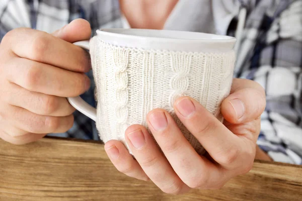 Cup warmer with male hand close-up