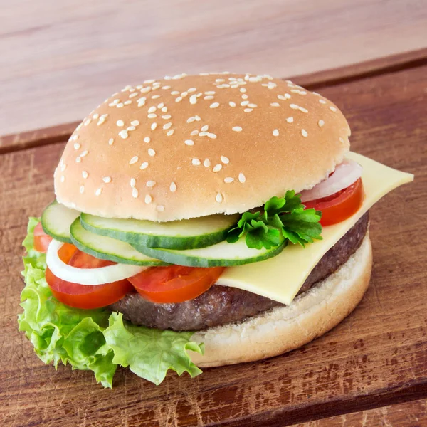 Cheeseburger em um fundo de madeira — Fotografia de Stock