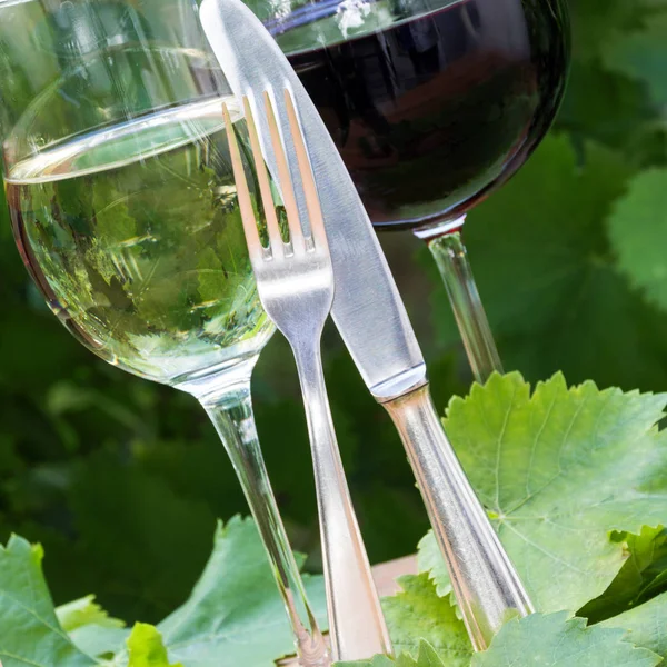 Красное, белое вино в стаканах со столовыми приборами — стоковое фото