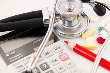 Stetoskop Tabletleri, hesap makinesi ve kırmızı kalem yakın çekim