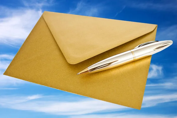 Golden envelope with ballpoint pen — Stock Photo, Image