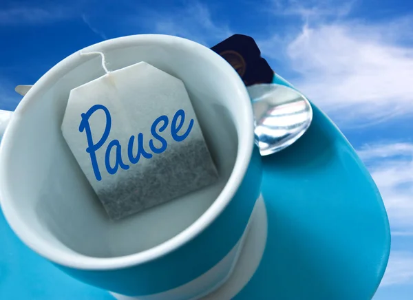 Break tea bag in cup with sky background