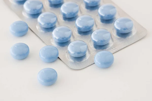 Medizin blaue Tabletten im Blister auf weißem Hintergrund — Stockfoto