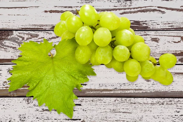 Uvas y hojas de vino en el fondo — Foto de Stock