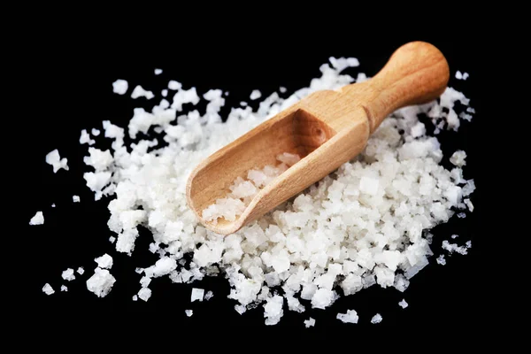 Salt grains on wood scoop close-up — Stockfoto