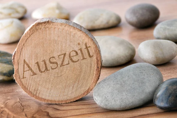 Auszeit Holzscheibe mit Steinen als Hintergrund — Stockfoto