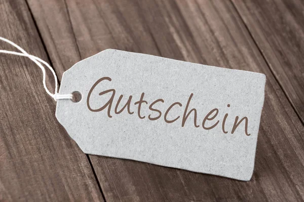 Deutsches Gutscheinetikett auf Holz als Hintergrund — Stockfoto