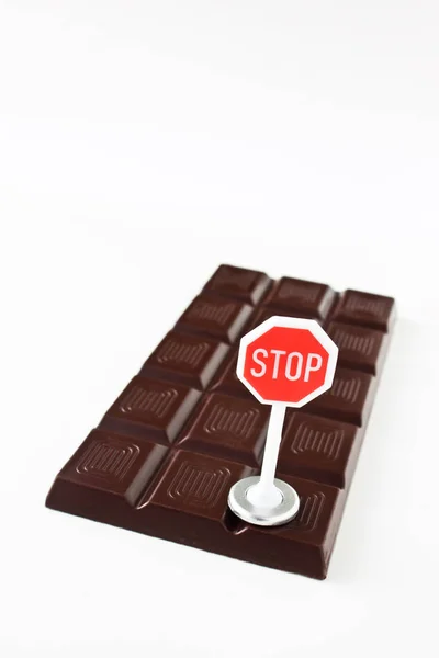 Chocolate and stop sign on white background close-up — Stockfoto