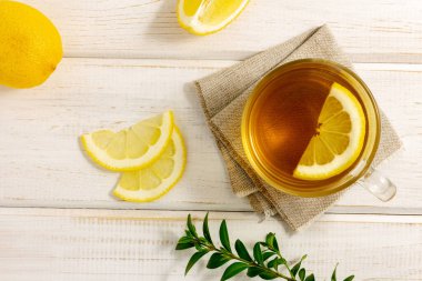 Beyaz ahşap arka planda limonlu bir fincan çay. Doğal C vitamini, alternatif tıp, sağlıklı yaşam tarzı. Üst görünüm.