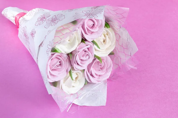 Bouquet of edible roses made from marshmallows on a pink background. Romantic food. Sweet present. Copy space.