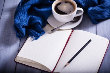 Notebook and cup of coffe  on wooden backgraund