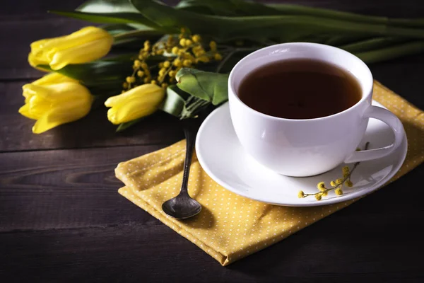 Żółte Tulipany Drewnianym Tle Filiżanką Herbaty — Zdjęcie stockowe