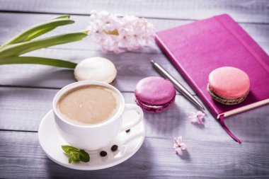 Ahşap zemin üzerinde pembe sümbül olan pembe badem kurabiyesi.