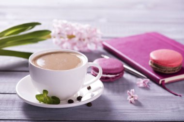 Ahşap zemin üzerinde pembe sümbül olan pembe badem kurabiyesi.