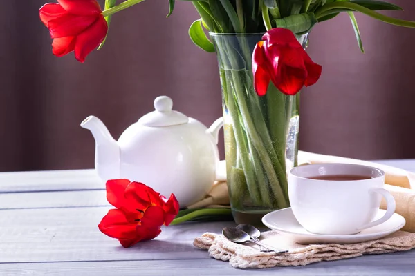 木のテーブルの上に花瓶にお茶 白いケトルと赤いチューリップのカップ — ストック写真