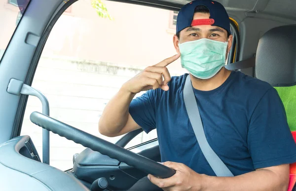 Toza ve gribe karşı korunmak için maske takan Asyalı kamyon şoförlerinin yakın plan fotoğrafları. Covid 19. Arabanın içinde.