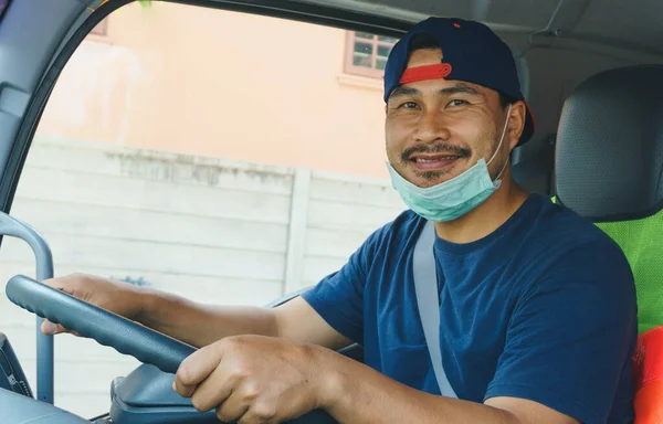 Toza ve gribe karşı korunmak için maske takan Asyalı kamyon şoförlerinin yakın plan fotoğrafları. Covid 19. Arabanın içinde.