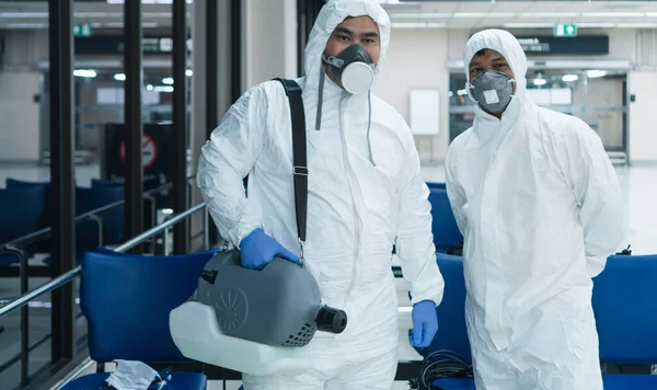 危险区域病毒正在迅速蔓延 两名亚洲医务人员穿着防护服 戴着口罩 目前正在该地区工作 以喷洒病毒 — 图库照片