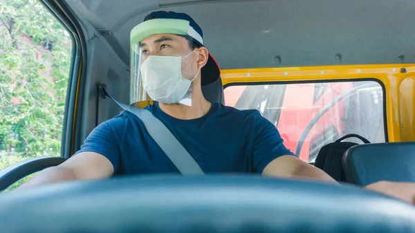 Toza ve gribe karşı korunmak için maske takan Asyalı kamyon şoförlerinin yakın plan fotoğrafları. Covid 19. Arabanın içinde.