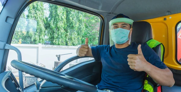 Toza ve gribe karşı korunmak için maske takan Asyalı kamyon şoförlerinin yakın plan fotoğrafları. Covid 19. Arabanın içinde.