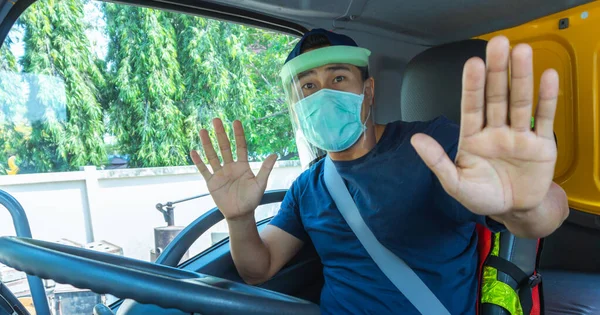 Toza ve gribe karşı korunmak için maske takan Asyalı kamyon şoförlerinin yakın plan fotoğrafları. Covid 19. Arabanın içinde.