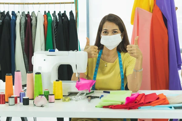 아시아의한 디자이너겸 재단사가 방에서 일하고 그녀는 먼지로부터 보호하고 감염을 마스크를 — 스톡 사진