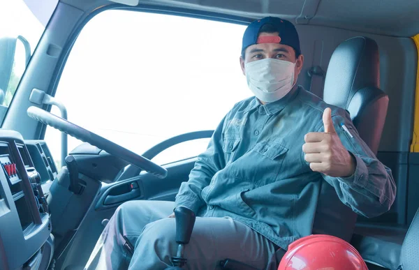 Toza ve gribe karşı korunmak için maske takan Asyalı kamyon şoförlerinin yakın plan fotoğrafları. Covid 19. Arabanın içinde.