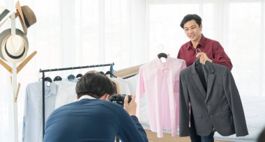 İki Asyalı erkek sosyal medya aracılığıyla ürünleri inceleyip satarken eğleniyor.