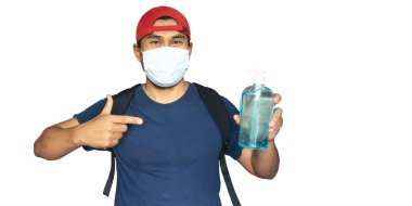 Anti-Covid Konsepti. Spor adamı koruyucu bir maske takıyor ve elinde dezenfektan tutuyor. Savaş ve kendini korona virüsünden koru..