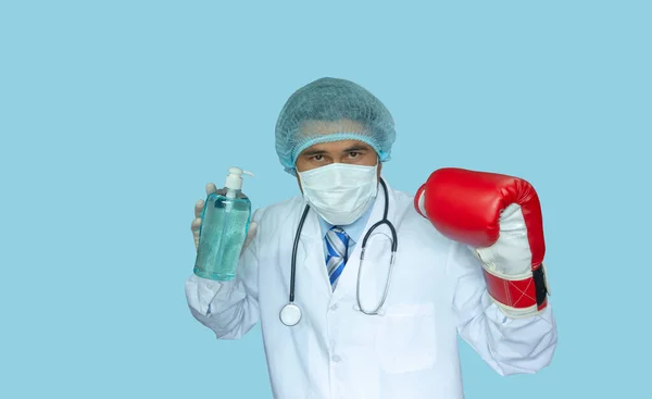 反Covid概念 亚洲医生戴着防护面具 准备动手术 蓝色的背景 洗手用的消毒剂 拳击手套就是打架 — 图库照片