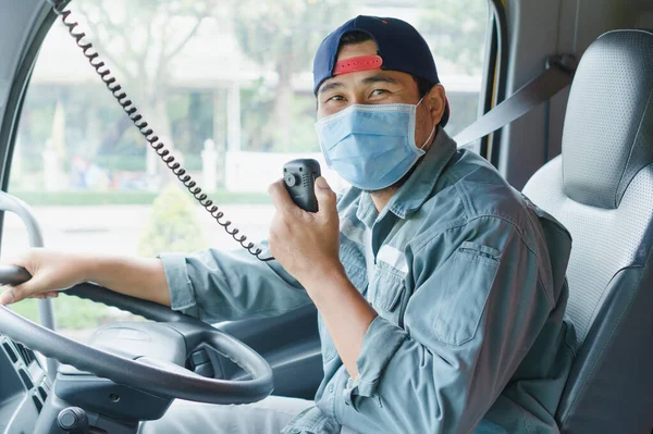 Toza ve gribe karşı korunmak için maske takan Asyalı kamyon şoförlerinin yakın plan fotoğrafları. Covid 19. Arabanın içinde.