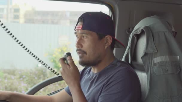 アジアのトラック運転手は車内で通信するために無線を使用しています 車で陸路輸送 — ストック動画