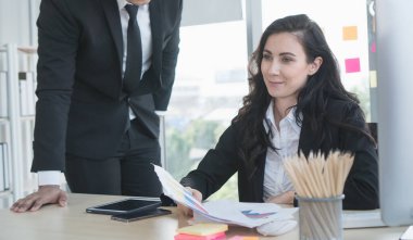 Beyaz iş adamları ve kadınlar ofiste mutlu bir şekilde birlikte çalışıyorlar. Bir video görüşmesiyle görüşüyorlar. İş ortaklarıyla ticaret yapmak için.