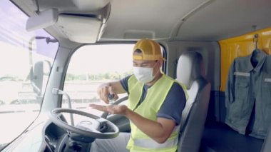 Yeni Normal Konsept - Kamyon şoförü havaya toz ve virüslerin yayılmasını önlemek için tıbbi maske takıyor.