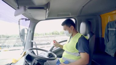 Yeni Normal Konsept - Kamyon şoförü havaya toz ve virüslerin yayılmasını önlemek için tıbbi maske takıyor.