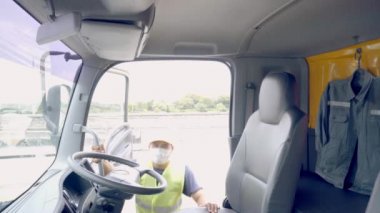 Yeni Normal Konsept - Kamyon şoförü havaya toz ve virüslerin yayılmasını önlemek için tıbbi maske takıyor.