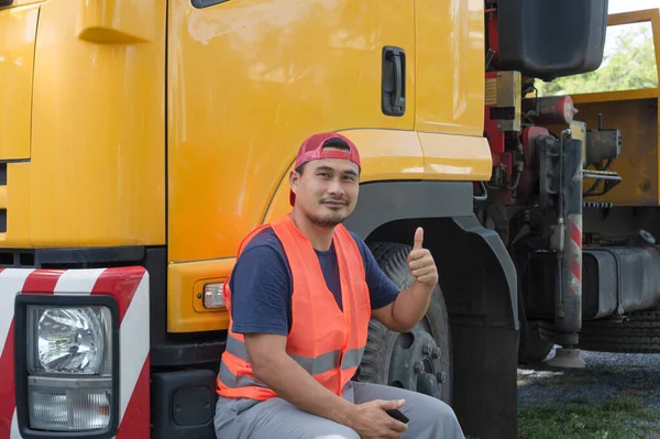 Asyalı bir adam sarı kamyona mutlu bir şekilde gülümsüyordu. Nakliye şoförü olarak bir kariyeri var. Ulaşım işi asla bitmez. Her zaman sürülüp seyahat edilmeli..