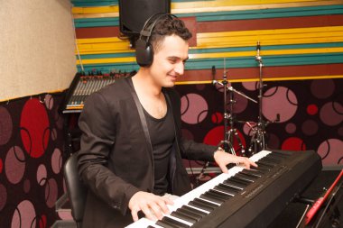 young handsome man playing on a synthesizer clipart
