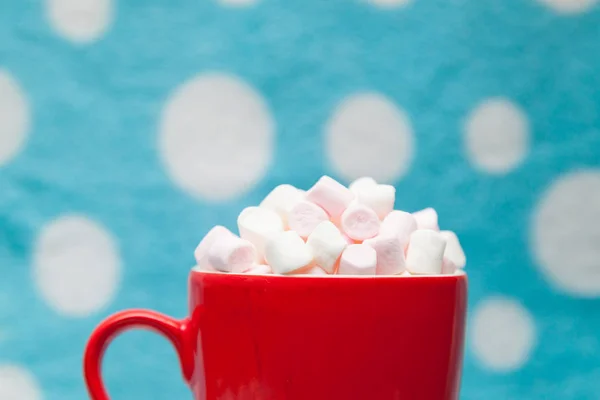 Marshmallow in a red cup on a blue background — Stock Photo, Image