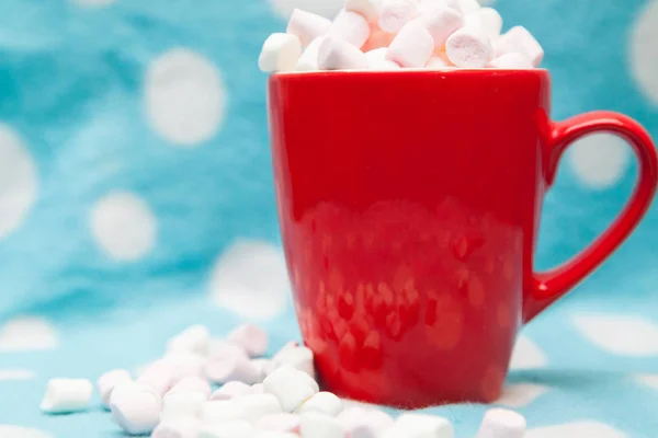 Marshmallow in una tazza rossa su sfondo blu — Foto Stock
