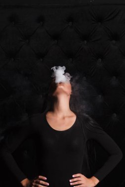 Elektronik sigara içen seksi esmer kadın.