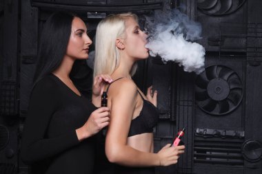 İki seksi kadın sigara elektronik sigara