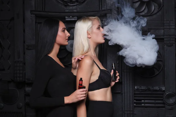 Δύο σέξι γυναίκα καπνίζοντες ηλεκτρονικό τσιγάρο — Φωτογραφία Αρχείου