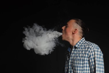 Genç adam elektronik sigara içiyor.