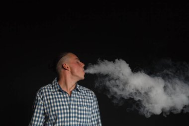 Genç adam elektronik sigara içiyor.