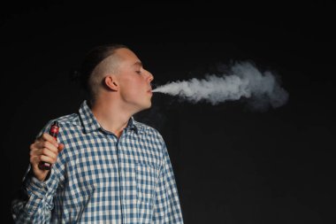 Genç adam elektronik sigara içiyor.