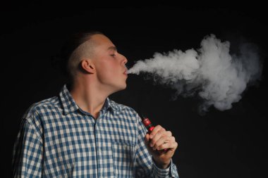Genç adam elektronik sigara içiyor.